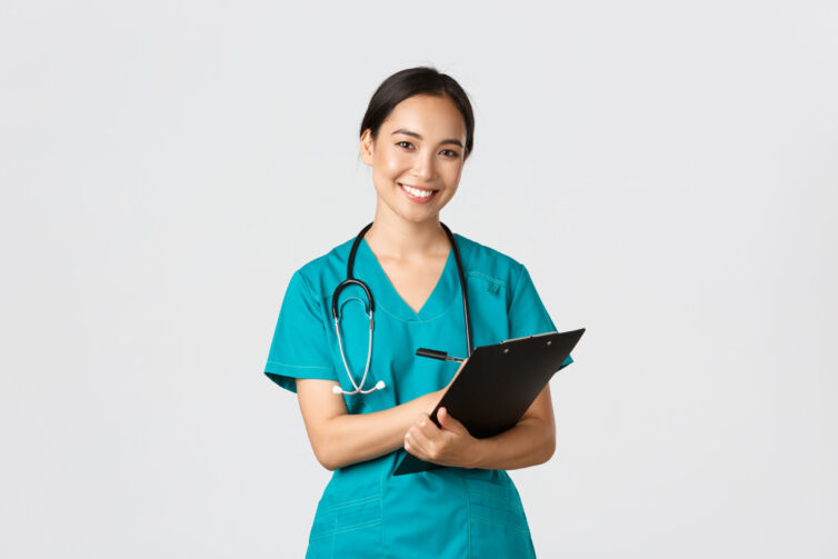 Healthcare workers, preventing virus, quarantine campaign concept. Cheerful friendly asian female physician, doctor with clipboard during daily checkup, standing white background